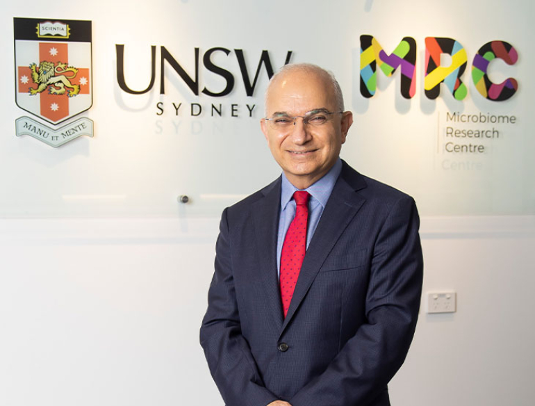 Professor Emad El-Omar in front of MRC and UNSW logos